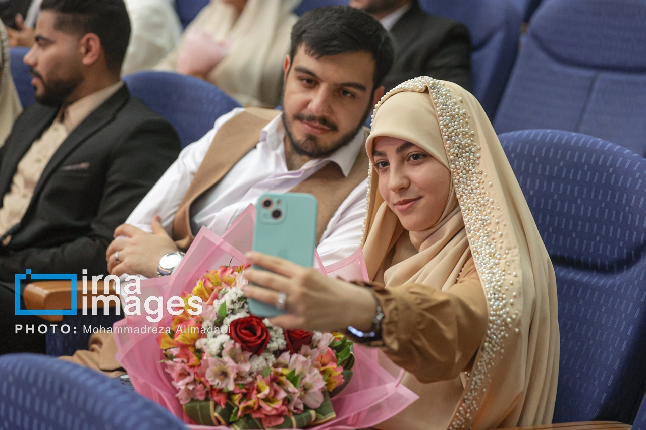 زوج جوان در حال گرفتن سلفی با دستهگل در مراسم ازدواج دانشجویی