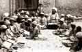 کودکان نشسته گرداگرد معلم در حال آموزش در مکتب‌خانه‌ای سنتی