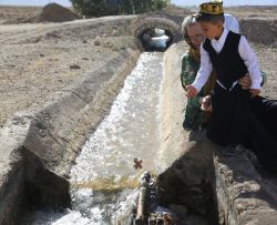 کودک در حال رهاسازی آدمک آش ابودردا در آب روان