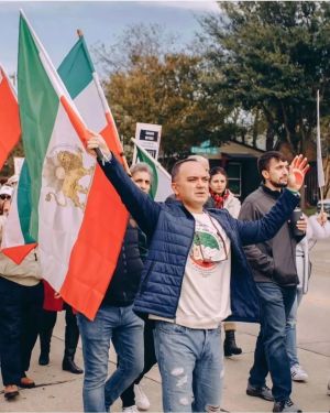 احسان کرمی با پرچم سلطنت‌طلبان در تجمع ضد ایرانی در آمریکا