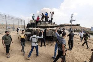 فلسطینی‌ها روی یک تانک اسرائیلی پس از عبور از حصار مرزی با اسرائیل از خان یونس در جنوب نوار غزه