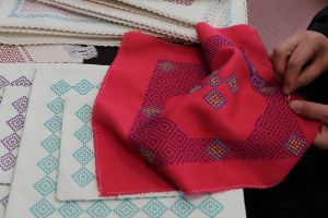 تصویری از یک بانو در حال درویش‌دوزی