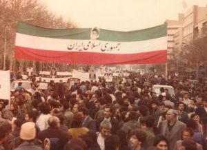 عکس قدیمی راهپمایی مردم ایران با پرچم ایران که بر روی آن جمهوری اسلامی ایران نوشته شده